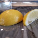 Acidic lemon wedge laying on marble countertops without etching