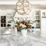 Beautiful floral arrangement at center of marble kitchen island